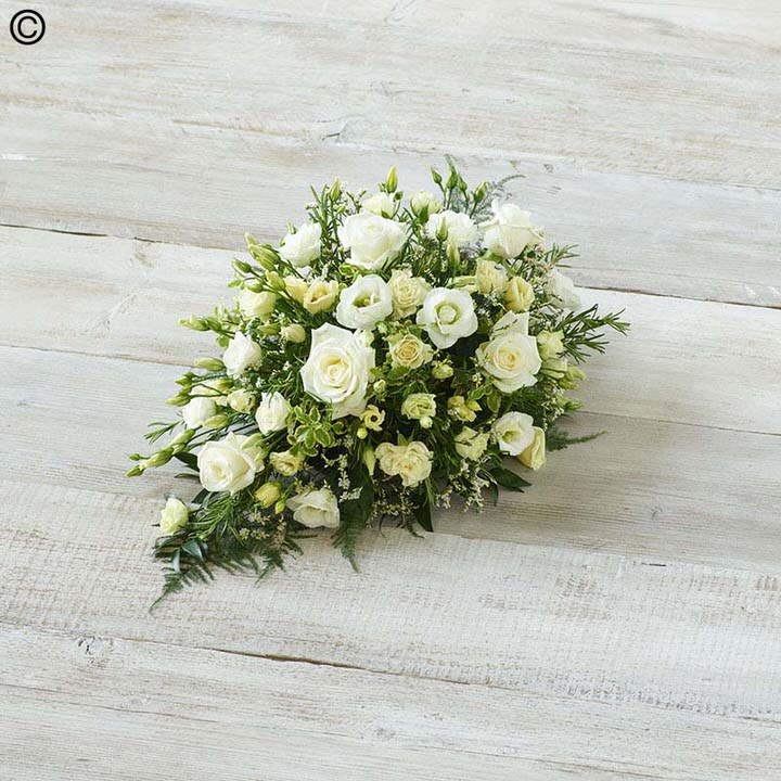 <h2>White Children's Casket Spray | Funeral Flowers</h2>
<ul>
<li>Approximate Size 70cm x 30cm</li>
<li>Hand created classic white casket spray in fresh flowers</li>
<li>To give you the best we may occasionally need to make substitutes</li>
<li>Funeral Flowers will be delivered at least 2 hours before the funeral</li>
<li>For delivery area coverage see below</li>
</ul>
<br>
<h2>Liverpool Flower Delivery</h2>
<p>We have a wide selection of casket flowers offered for Liverpool Flower Delivery. Casket flowers can be provided for you in Liverpool, Merseyside and we can organize Funeral flower deliveries for you nationwide. Funeral Flowers can be delivered to the Funeral directors or a house address. They can not be delivered to the crematorium or the church.</p>
<br>
<h2>Flower Delivery Coverage</h2>
<p>Our shop delivers funeral flowers to the following Liverpool postcodes L1 L2 L3 L4 L5 L6 L7 L8 L11 L12 L13 L14 L15 L16 L17 L18 L19 L24 L25 L26 L27 L36 L70 If your order is for an area outside of these we can organise delivery for you through our network of florists. We will ask them to make as close as possible to the image but because of the difference in stock and sundry items it may not be exact.</p>
<br>
<h2>Liverpool Funeral Flowers | Casket Flowers</h2>
<p>This children's casket spray has been loving handcrafted by our expert florists. The selection of stunning flowers in snow white shades gives grace and simplicity to this casket spray. The design features calla lilies, sweetly scented freesia, large-headed roses, lisianthus and September flowers, arranged with seasonal foliages and ivy trails.</p>
<br>
<p>Funeral Casket Flowers the main tribute and are sometimes, depending on the family's wishes, the only flower arrangement. They are usually chosen by the immediate family.</p>
<br>
<p>Casket sprays are placed directly on top of the coffin. The sprays are large diamond shape tributes. The flowers are arranged in floral foam, which means the flowers have a water source meaning they look their very best for the day.</p>
<br>
<p>Containing 3 white roses, 5 white calla lilies, 4 white freesia, 3 white lisianthus, 2 white September flower and seasonal mixed foliage.</p>
<br>
<h2>Best Florist in Liverpool</h2>
<p>Trust Award-winning Liverpool Florist, Booker Flowers and Gifts, to deliver funeral flowers fitting for the occasion delivered in Liverpool, Merseyside and beyond. Our funeral flowers are handcrafted by our team of professional fully qualified who not only lovingly hand make our designs but hand-deliver them, ensuring all our customers are delighted with their flowers. Booker Flowers and Gifts your local Liverpool Flower shop.</p>
<br>
<p><em>Janice Crane - 5 Star Review on Google - Funeral Florist Liverpool</em></p>
<br>
<p><em>I recently had to order a floral tribute for my sister in laws funeral and the Booker Flowers team created a beautifully stunning arrangement. Thank you all so much, Janice Crane.</em></p>